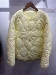 Detail of V-neck onion-quilted jacket in cream with buttons and size S neck label