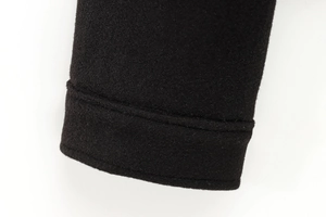 Close-up of the black textured wool fabric and neat seam stitching on the jacket sleeve