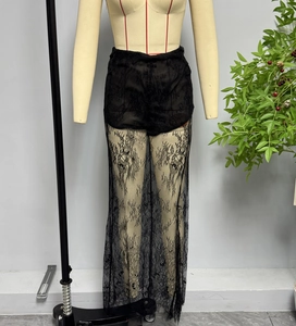 Dettaglio dei pantaloni in pizzo floreale nero a vita alta con fodera interna corta