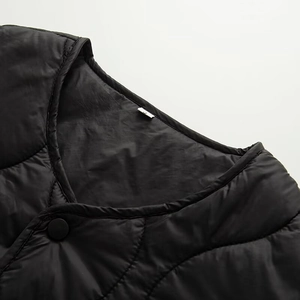 Detail of V-neck quilted jacket featuring wavy stitching and matte black snap buttons
