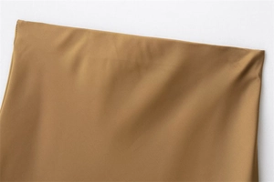 Detailed macro view of the waistline and satin fabric texture on a coffee midi skirt