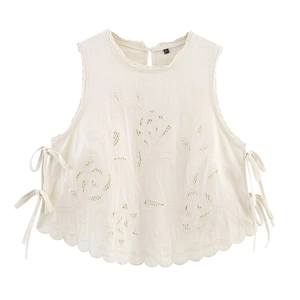 Detail of floral embroidery and side bow ties on a cream sleeveless cropped top