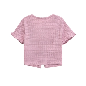 Detail of pink waffle knit top showing delicate ruffle sleeves and textured fabric detail