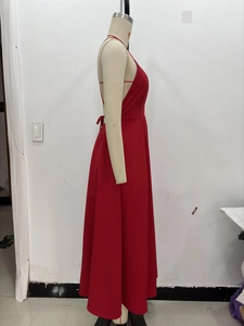 Detail view of the red halter neck dress showing backless design and pleated waist details