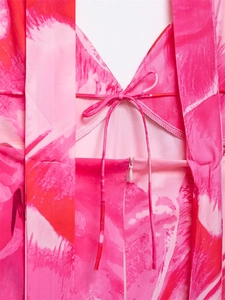 Détail du décolleté en V avec cordon de serrage et zip invisible sur robe rose imprimée