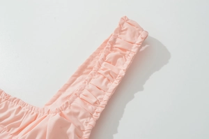 Close-up of pink ruffled shoulder strap showing premium stitching on cotton fabric