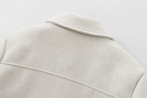 Close-up of the soft beige wool blend lapel and detailed stitching on the jacket collar