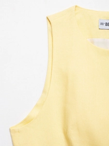Close-up of pale yellow cotton linen sleeveless top showing natural fabric texture