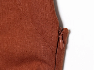 Détail du zip invisible sur robe midi en lin couleur caramel montrant la texture du tissu