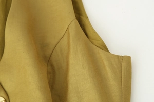 Dettaglio delle cuciture fini e della trama satinata premium di questo elegante top verde