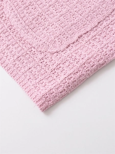 Detail of soft pink knit sweater showing premium waffle weave texture and honeycomb pattern
