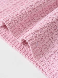 Close-up of pink waffle knit fabric showing detailed soft texture and delicate weave