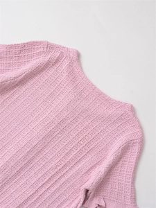 Detail of pink waffle knit top showing delicate ruffle edges and soft fabric texture