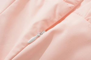 Detailed close-up of a concealed zipper on a light pink French style dress