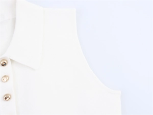 Détail d'un polo sans manches en maille blanche avec boutons dorés sphériques de qualité