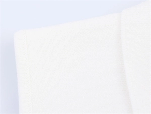 Gros plan sur le détail d'un tricot blanc haute densité montrant des coutures lisses