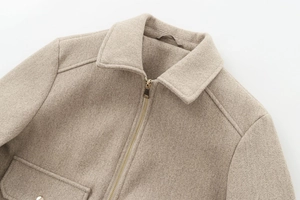 Close-up of soft beige wool jacket featuring premium metal zipper and textured fabric