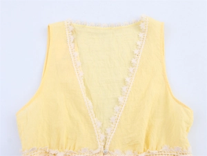 Detailed view of the white lace trim and V-neckline on this yellow sleeveless summer top