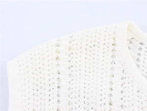 Détail du motif en maille ajourée complexe sur l'encolure de cette robe longue beige