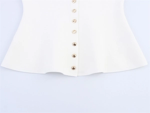 Détail d'un cardigan blanc en maille avec sept boutons dorés et ourlet à volants