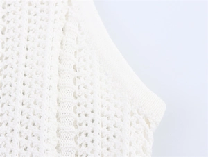 Détail d'une robe en maille blanche avec texture crochet ajourée et finitions soignées