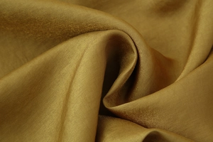 Macro di tessuto in raso bronzo con lucentezza metallica e dettagli di pieghe eleganti