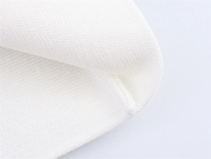 Détail macro du tissu en maille côtelée blanche montrant la texture douce et la qualité