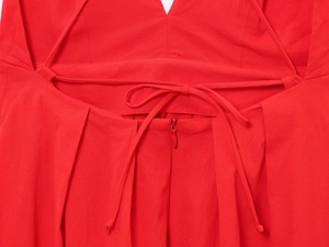 Detail of red backless dress showing cross straps and hidden back zipper closure