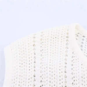 Détail de haut en crochet blanc montrant les textures ajourées et la finition du col