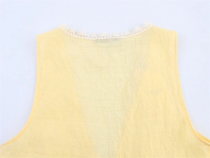 Detail of yellow sleeveless top featuring delicate white lace trim on the neckline