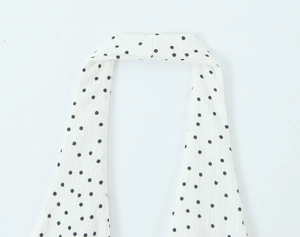 Détail du col licou et du motif à pois sur un débardeur en mousseline blanche