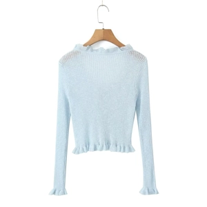 Close-up of light blue ribbed knit cardigan with ruffle trim details on white background
