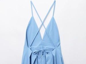 Detail of light blue dress showing backless V-neck design and cross straps with invisible zipper