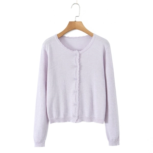 Detail of lavender knit cardigan showing scalloped edges and matching round buttons