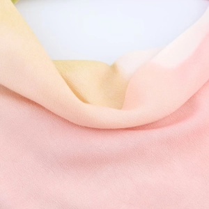 Detail shot of lightweight gradient fabric with crepe texture in beige and pink tones
