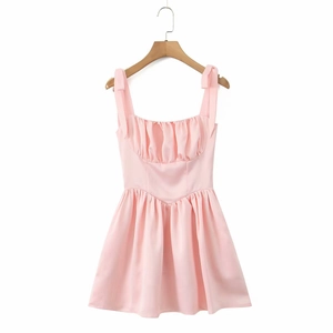 Detail of light pink summer dress with bow shoulder straps and pleated bust texture