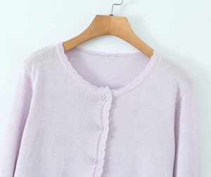Detail of lavender knit cardigan showing delicate crochet lace trim and clear buttons
