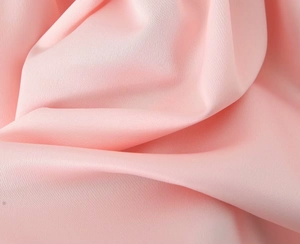 Detailed close-up of soft pink satin fabric with a silky texture and elegant drape
