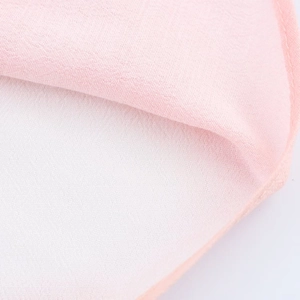 Macro detail of pink chiffon fabric showing fine texture and quality overlock stitching
