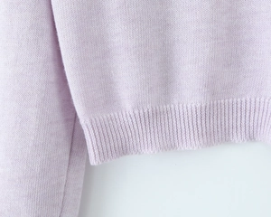 Close-up of lilac knit cardigan showing detailed ribbing hem and soft fabric texture