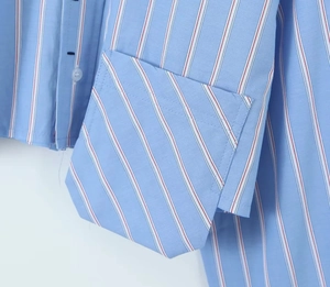 Détail d'une chemise à rayures bleu clair avec poche poitrine à motif diagonal contrasté