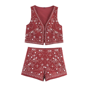 Détail de broderie et paillettes miroir sur ensemble gilet et short rouge ethnique