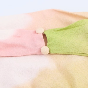 Macro detail of gradient fabric texture and fabric-covered buttons on the dress