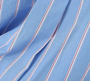 Gros plan d'un tissu de chemise bleu clair avec de fines rayures rouges et blanches