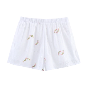 Détail du short en coton blanc avec broderie florale et texture ajourée