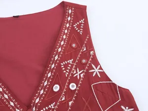 Détail de la broderie miroir ethnique et du motif blanc sur le gilet en lin bordeaux