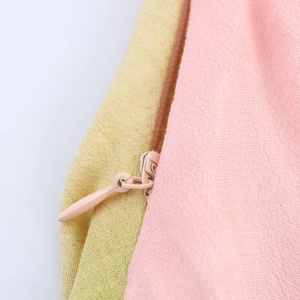 Detail of the hidden zipper on pink and green floral print halter dress fabric