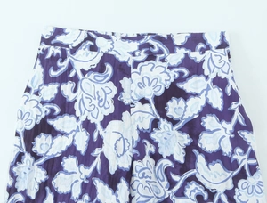 Vista dettagliata dei pantaloni a fiori viola con vita alta e trama del tessuto traspirante
