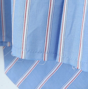 Gros plan du tissu de chemise à rayures bleu clair montrant le tissage et l'ourlet