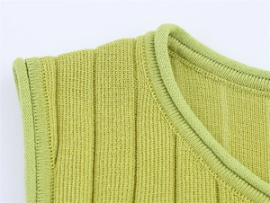 Detail of green ribbed knit top showing vertical texture and high-quality edge stitching